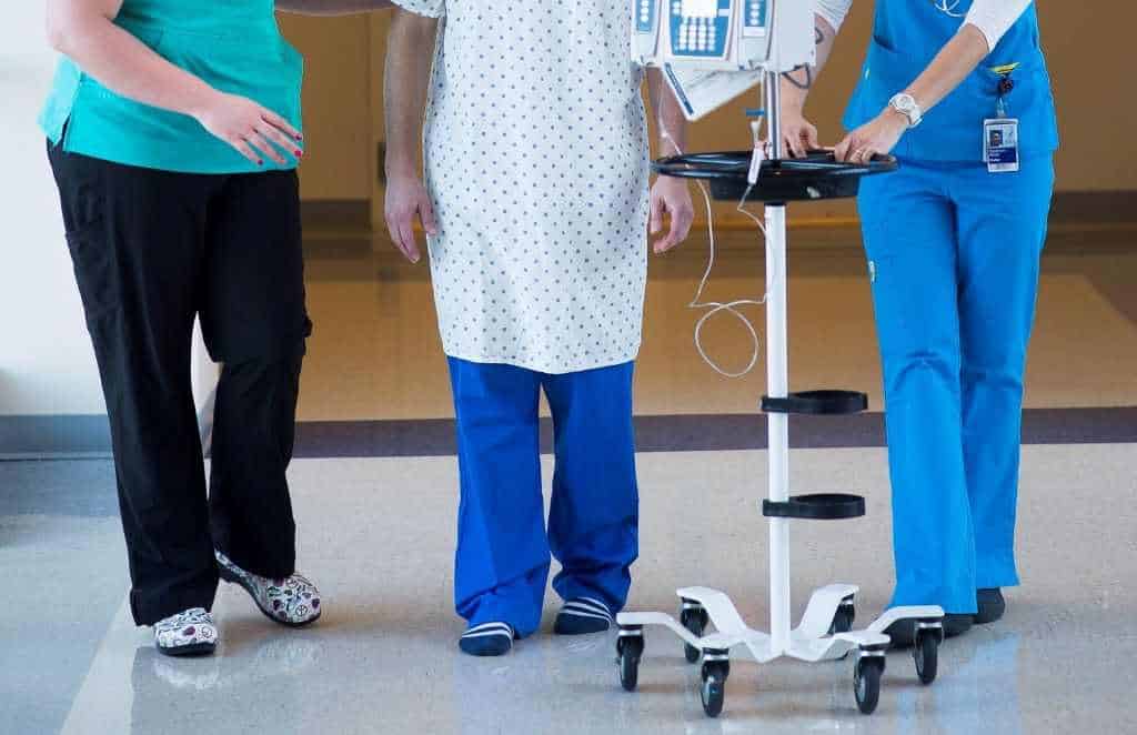 two women nurses walking a patient