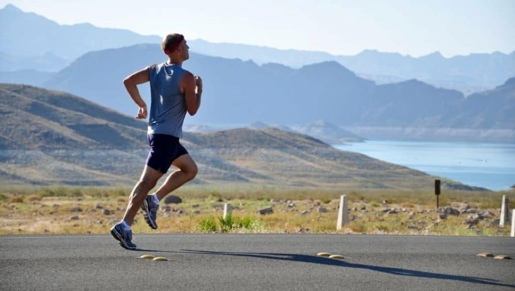 man in blue tank top, black shorts and running shoes outfit