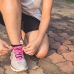 woman tying her shoes before running