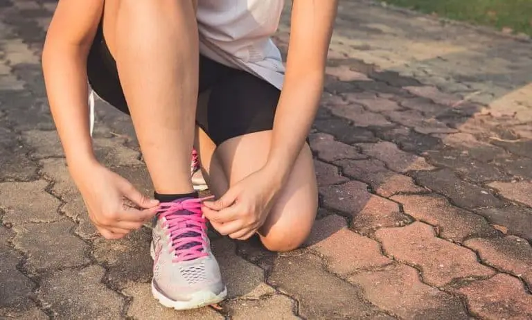 woman tying her shoes before running