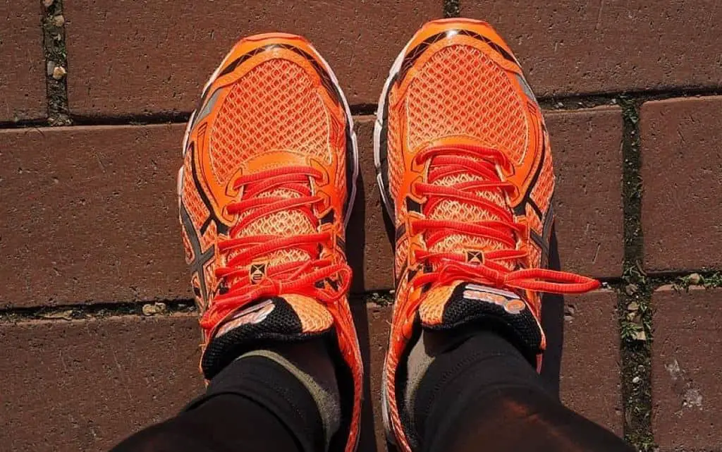 Closeup photo of person wearing orange-and-black running shoes