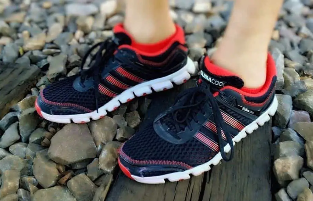 Person wearing black red and white running shoes