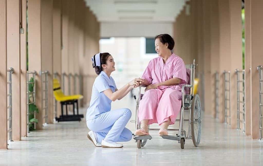 elderly woman on a wheelchair and nurse at the hospital