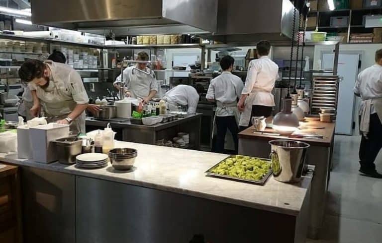 men cooking on commercial griddle and walking in the kitchen