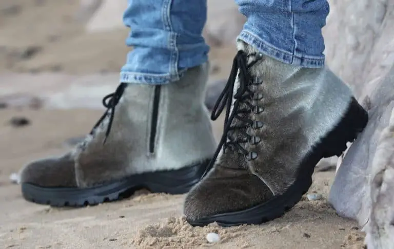 person on grey boots and blue jeans