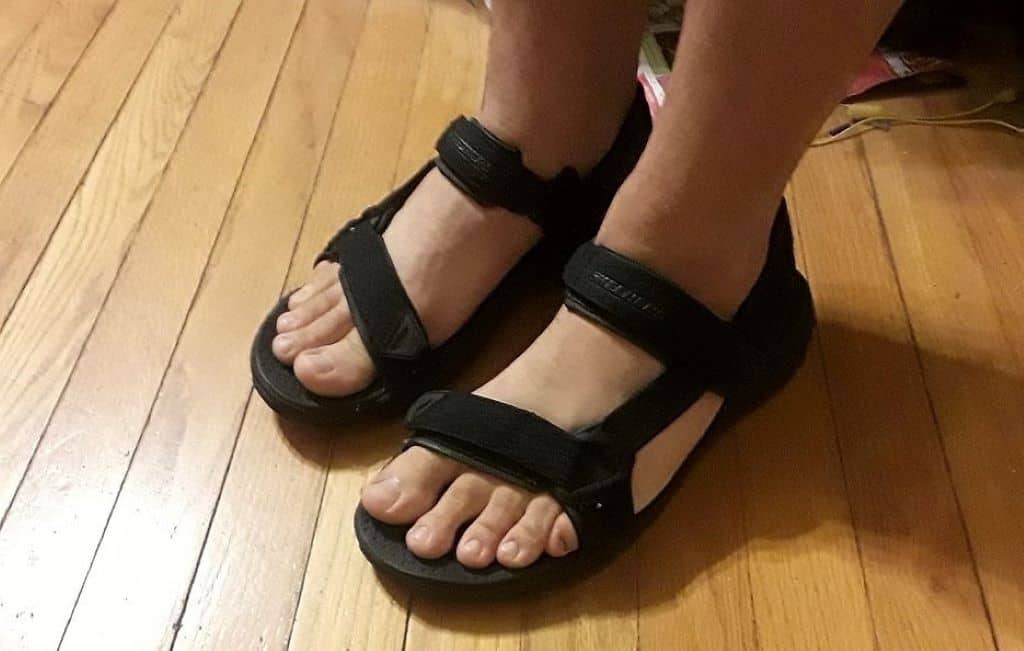 person wearing black hiking sandals