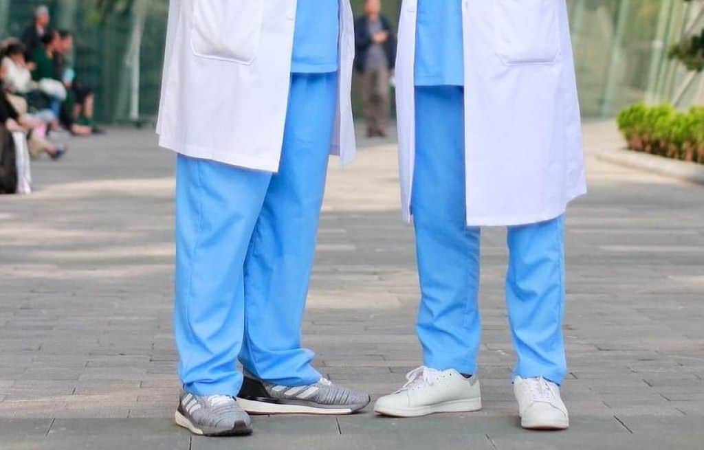 two male doctors wearing lab coats smiling